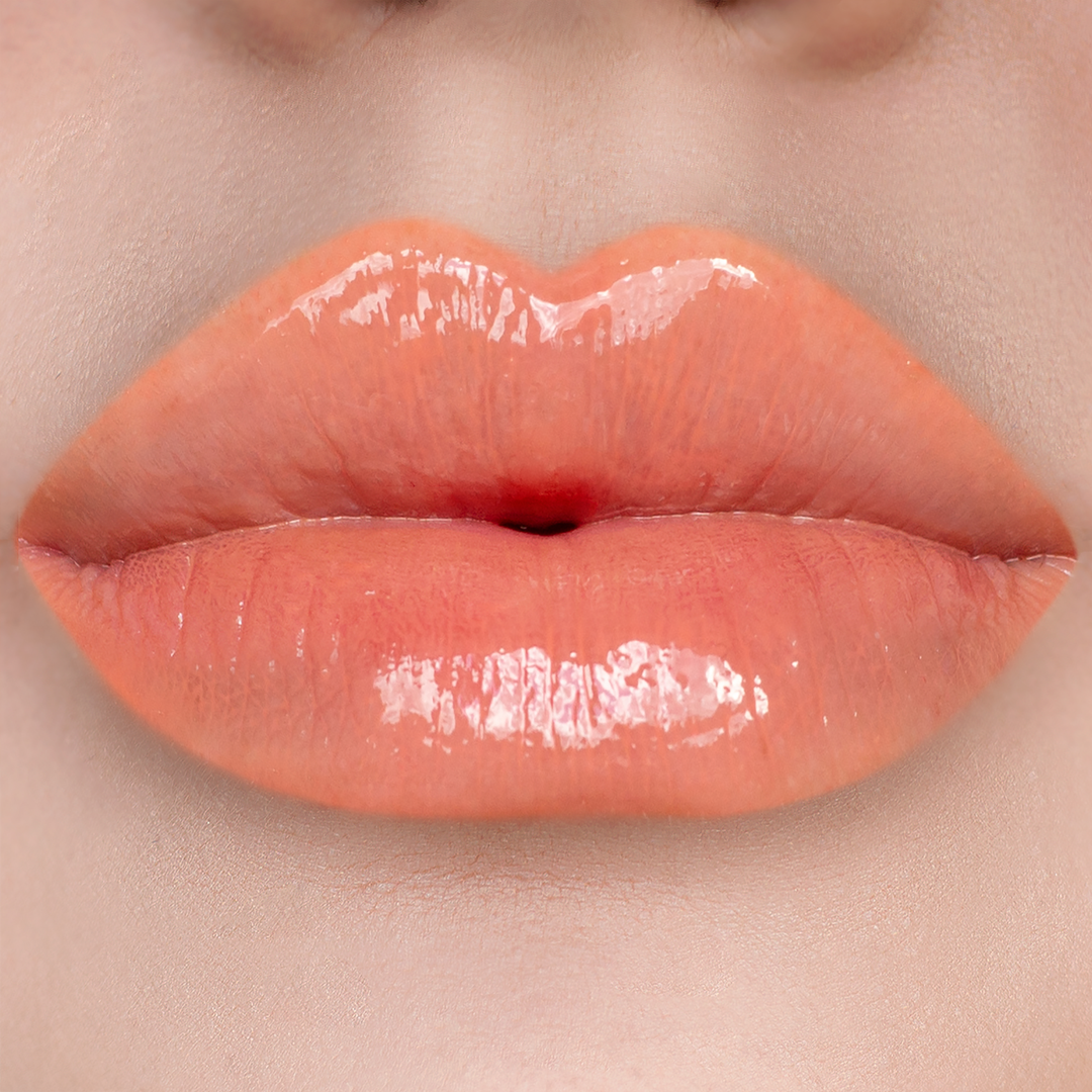 Strapless peach coral lip gloss on lips, light skin tone