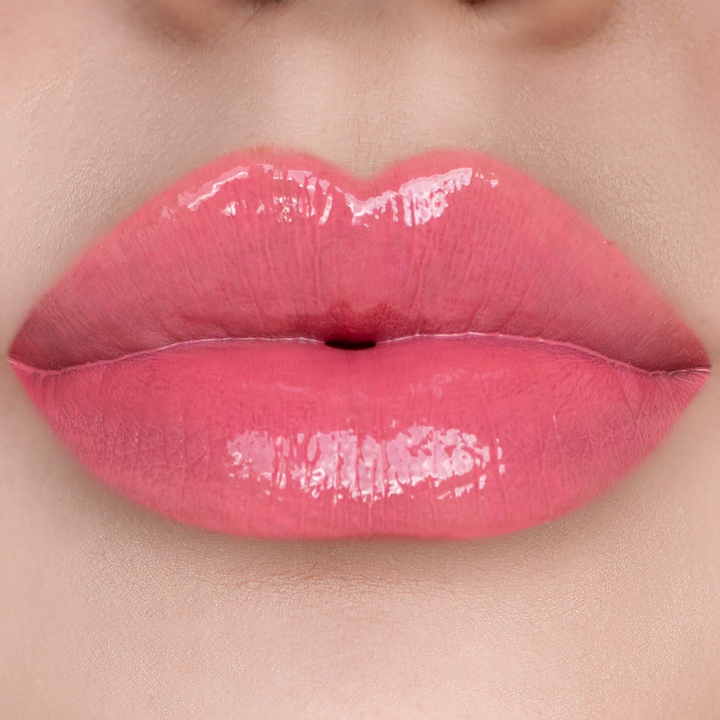 Glossy Stripped coral pink lip gloss on lips, light skin tone