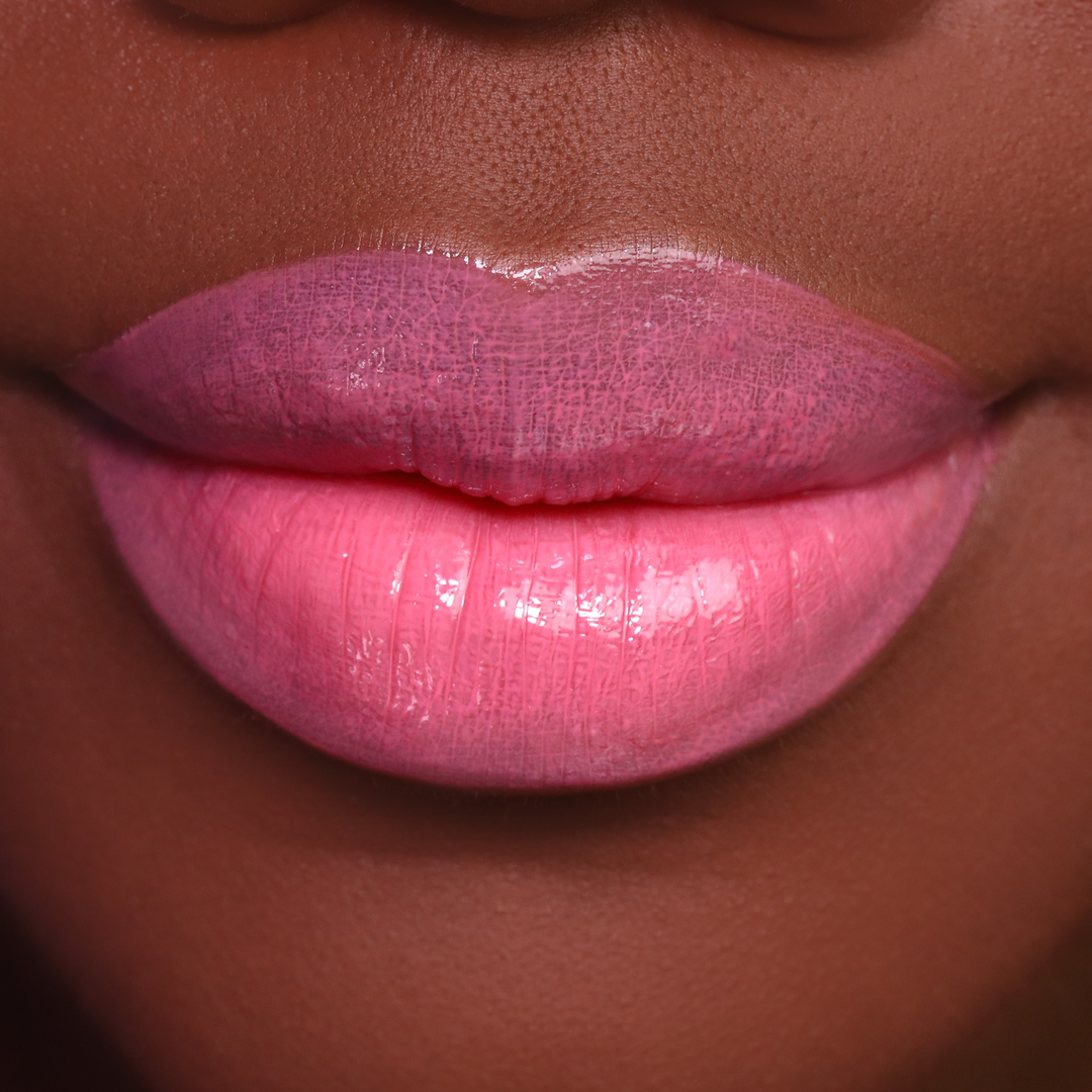 Glossy Stripped pink lip gloss on lips, deep skin tone