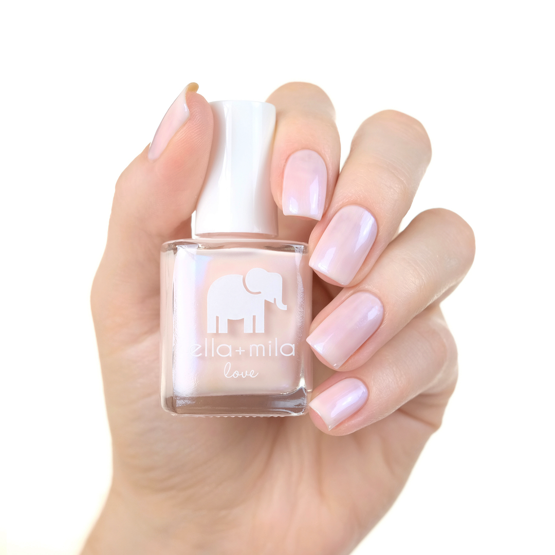 Stuck On You sheer pink nail polish manicure on a light skin tone with the bottle
