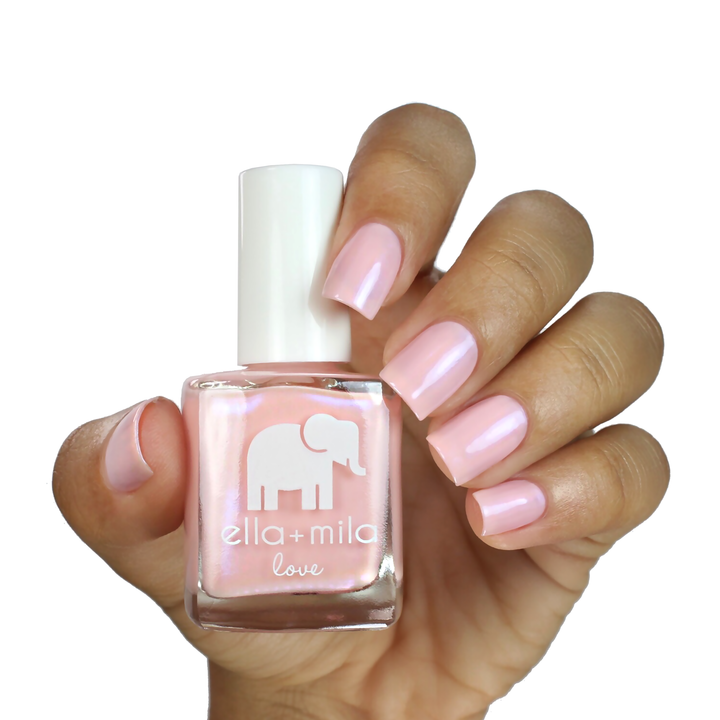 Stuck On You soft iridescent pink nail polish on a medium skin tone, hand holding the bottle