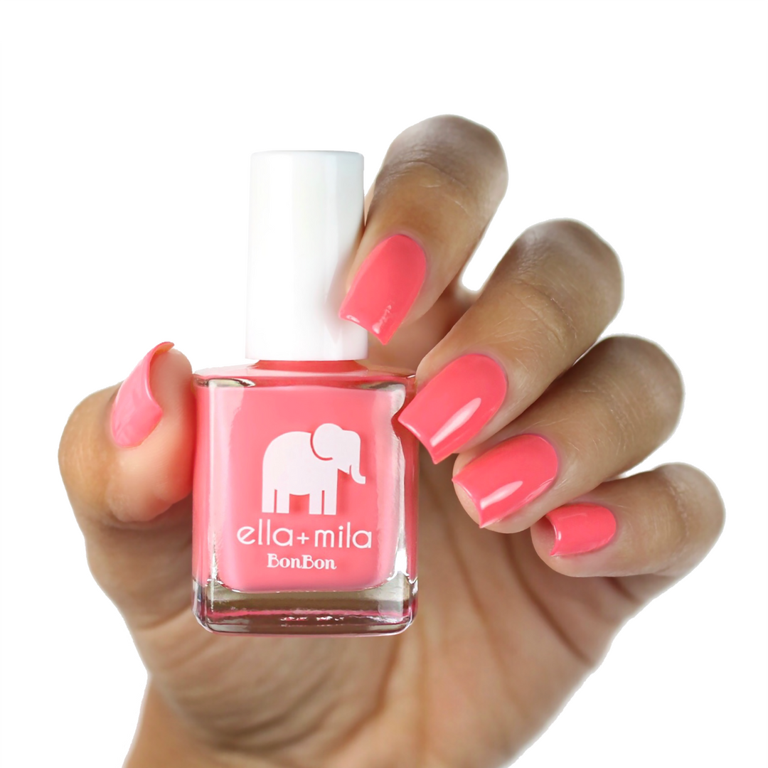 Sweet Tooth peachy pink nail polish on a medium skin tone, hand holding the bottle