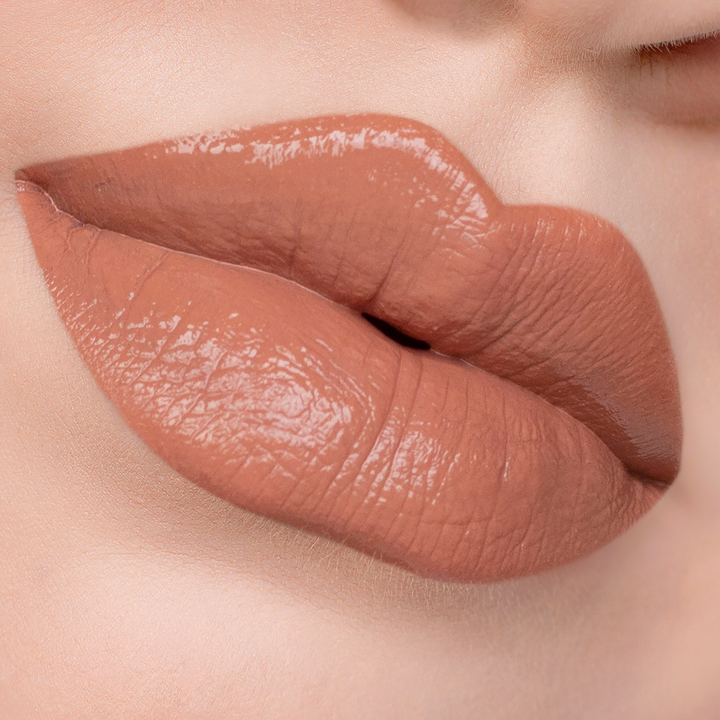 Twisted peachy nude lipstick on lips, light skin tone close-up