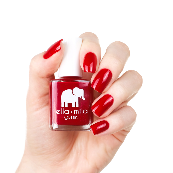 Unwrap Me festive red nail polish manicure on a light skin tone with the bottle
