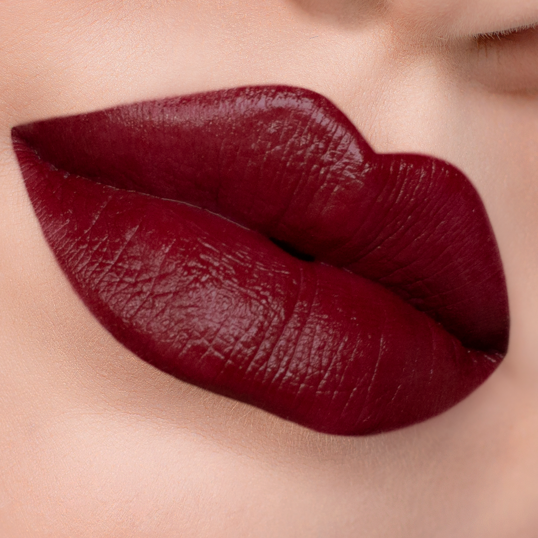 Vampy deep red lipstick on lips, light skin tone close-up