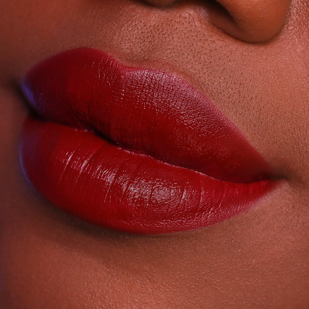 Vampy deep red lipstick on lips, deep skin tone close-up
