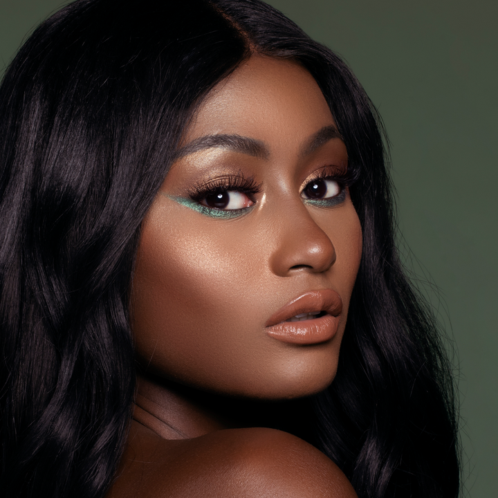 Model wearing Vibes lip gloss with a bronze glam look, deep skin tone