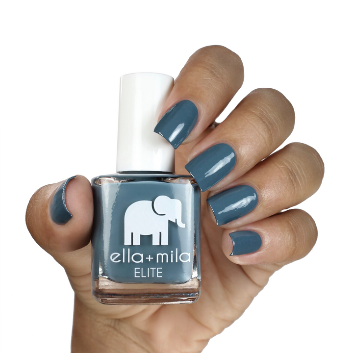 Yacht Club grey blue-green nail polish on a medium skin tone, hand holding the bottle